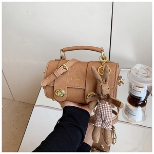 Brown barrel crossbody bag with gold Fashion logo and cute bunny doll accessory