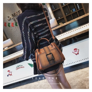 Détail d'un sac à main marron vintage avec grande boucle métallique et bandoulière