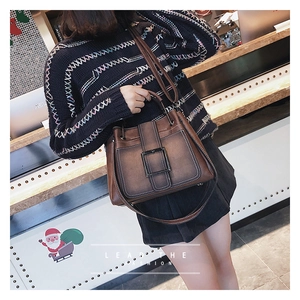 Détail du sac à main vintage marron foncé avec surpiqûres et grande boucle en métal