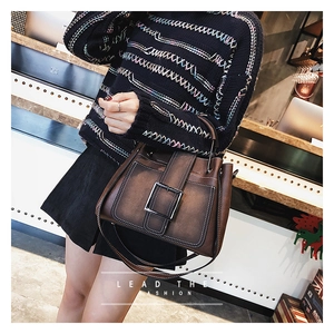 Détail d'un sac à main vintage marron avec grande boucle métallique et poignée chic