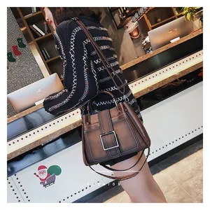 Détail du sac à main vintage marron avec surpiqûres contrastées et grande boucle en métal