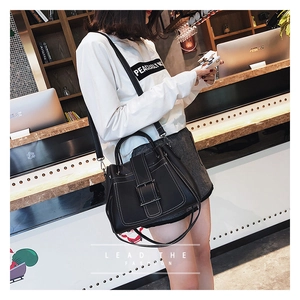 Détail du sac à main en cuir PU noir brillant avec boucle en métal et surpiqûres