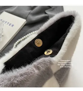 Detail view of the hidden magnetic buckle on grey plush checkerboard bucket bag