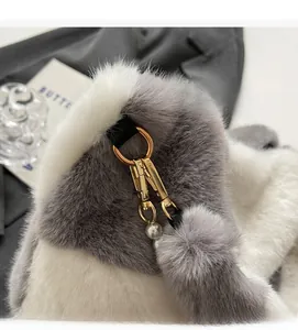 Close-up of golden metal buckle with white pearl and gray faux fur ball detail