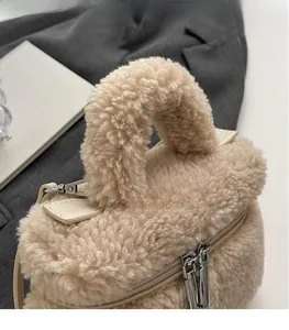 Gros plan sur la texture peluche beige avec fermeture éclair et détails en cuir