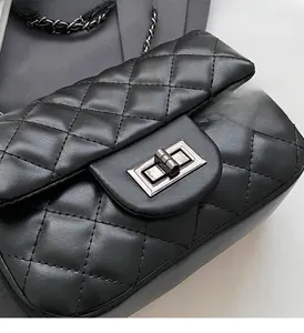 Close-up of diamond lattice texture and elegant silver twist lock on black leather bag