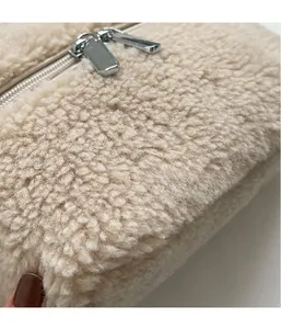 Détail du tissu sherpa doux et des doubles fermetures éclair en métal argenté du sac seau