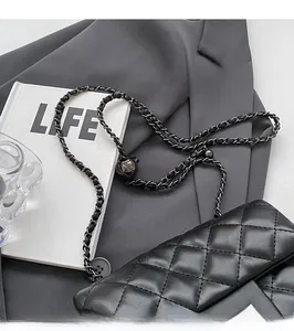 Detail of black quilted leather crossbody bag with adjustable gold ball chain strap