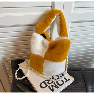 Detailed view of yellow and white plush checkerboard bucket bag with pearl handle