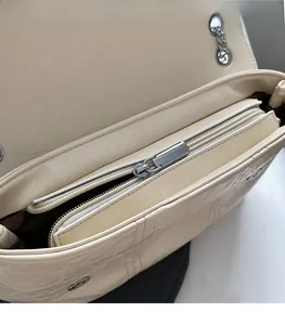 Close-up of internal zipper pocket and smooth metal puller on creamy white crossbody bag