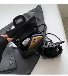 Detailed internal view of black quilted chain bag showing spacious capacity for phone