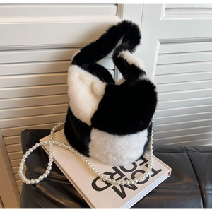 Close-up of faux fur bucket bag with black and white checkered pattern and pearl strap