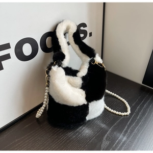 Detail of faux fur bucket bag with black and white patchwork and pearl chain