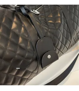Detail of black quilted travel bag showing premium faux leather texture and metal hardware