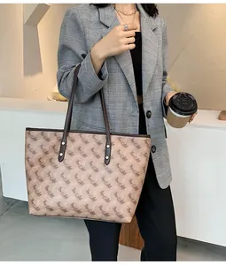 Detail of shoulder tote bag featuring beige brown horse pattern and leather handles