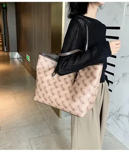 Brown monogram tote bag with leather handles shown on shoulder for daily commute