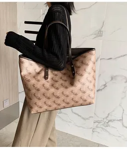 Detail of a large beige tote bag with brown horse pattern worn by a model