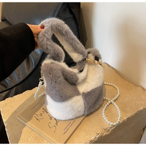Detail of grey and white checkered faux fur bucket bag with pearl crossbody strap