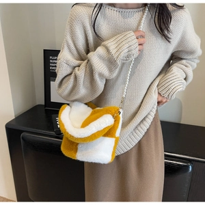 Detail of yellow and white checkered plush bag with elegant pearl chain strap