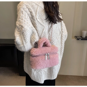 Détail d'un sac seau rose pelucheux avec fermetures éclair argentées et poignée douce