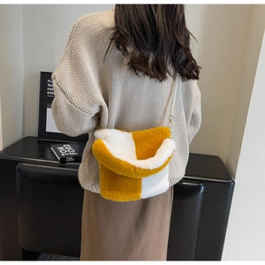 Detail of plush bucket bag with yellow and white faux fur and pearl strap accents