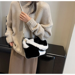 Detail of fuzzy checkerboard crossbody bag with elegant pearl strap on model