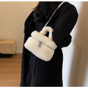 Vue détaillée du sac bandoulière en peluche beige avec fermetures éclair argentées