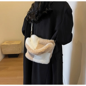 Detailed view of plush checkered bucket bag with elegant white pearl strap decoration