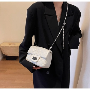 Close-up of white quilted leather chain bag with silver metallic rotary lock detail