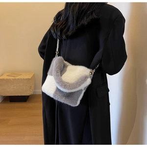 Detail of grey and white checkered faux fur bucket bag with pearl chain strap