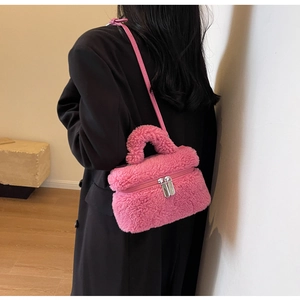 Détail du sac à bandoulière en peluche rose avec fermeture éclair argentée et poignée