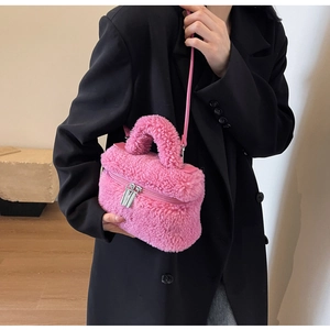 Détail du sac bandoulière en peluche rose avec fermetures éclair et texture agneau