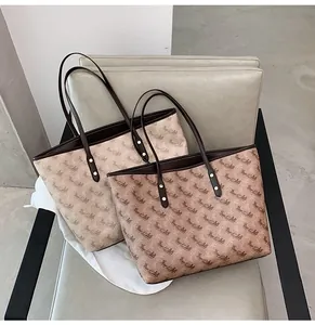 Close-up of classic horse carriage pattern and reinforced leather straps on tote bags