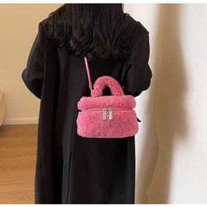 Détail du sac seau en peluche rose avec fermetures éclair et texture douce