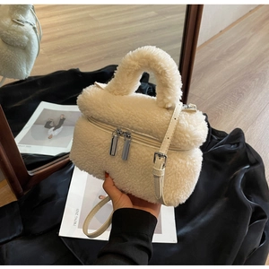 Détail du sac seau en laine d'agneau blanche avec fermetures éclair argentées