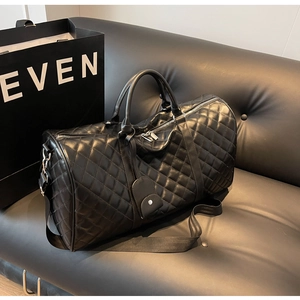 Detail shot of black quilted faux leather travel bag with diamond patterns and adjustable strap
