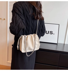 Borsa a secchiello plissettata bianco sporco con catena argento e logo sul modello