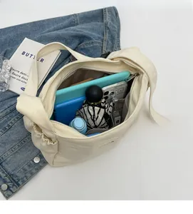 Detailed interior of large canvas tote bag showing multiple compartments and metal zipper