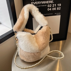 Plush color-block bucket bag with pearl strap on silver table, autumn winter style