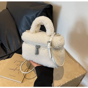 Détail d'un sac seau en peluche blanche avec double fermeture éclair et bandoulière