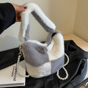 Faux fur checkered bucket bag with pearl chain strap on a black leather jacket