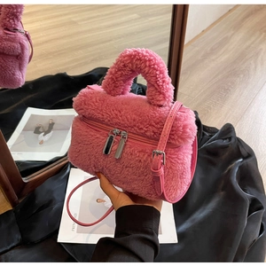 Détail du sac seau rose en fausse fourrure avec zips argentés et bandoulière cuir