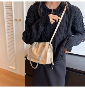 Dettaglio borsa a secchiello beige plissettata con catena argento e coulisse