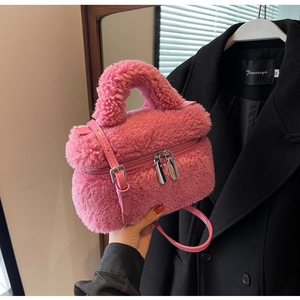 Gros plan détaillé du sac seau en peluche rose avec doubles fermetures éclair en métal
