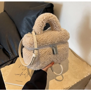 Détail du sac seau en peluche beige avec double zip et bandoulière réglable