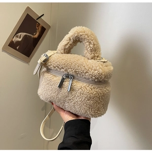 Détail du sac seau beige en peluche avec texture peau de mouton et doubles zips en métal