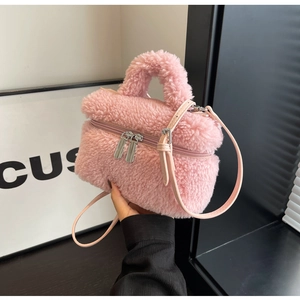 Détail du sac seau rose en peluche avec double fermeture éclair et poignée en fourrure