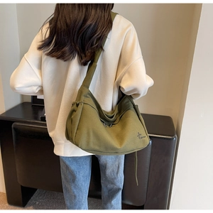 Detail of army green canvas tote bag with side drawstring and adjustable wide strap