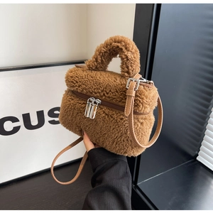 Vue détaillée de la texture pelucheuse marron et de la double fermeture éclair sur le sac seau