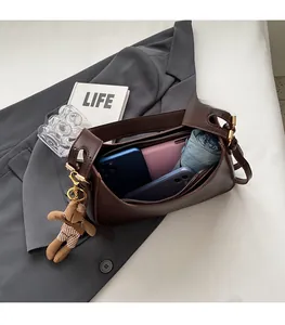 Spacious interior of dark brown leather shoulder bag with a cute bear charm